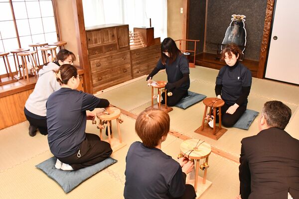 和の雰囲気が漂う店内で、大関組紐の制作を実演するスタッフら