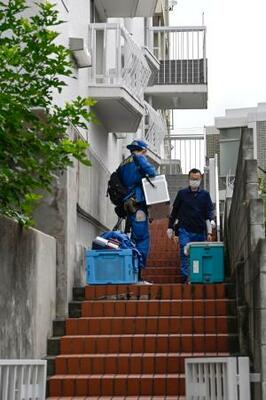 大型冷凍庫から成人男性の遺体が見つかったマンションに出入りする捜査員=22日午前、神戸市中央区