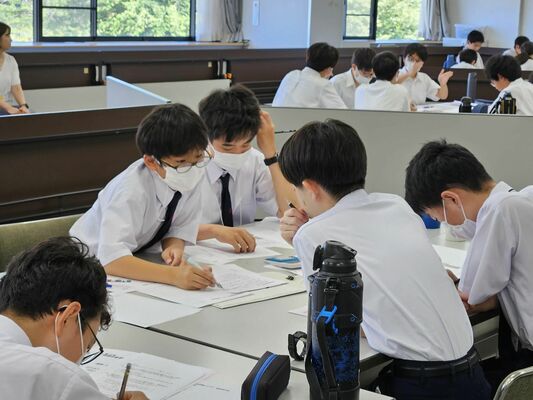 チームメイトと相談しながら問題に挑む参加者＝30日午前、宇都宮市瓦谷町