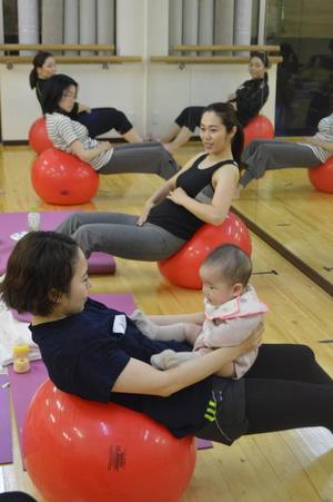 バランスボールを使った産後向けエクササイズを楽しむ女性たち＝５月下旬、宇都宮市