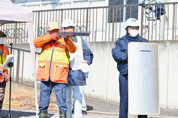 クマに向けて模擬銃を構える県猟友会安蘇支部員