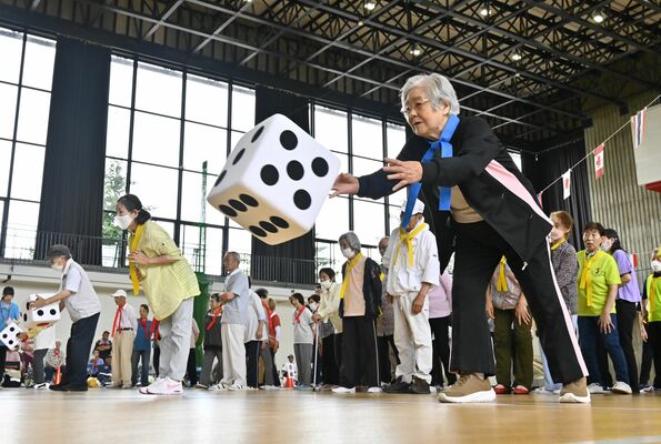 ジャンボサイコロを振って的に近づける競技に挑む参加者