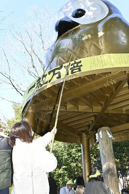 すすを払われる巨大フクロウ像