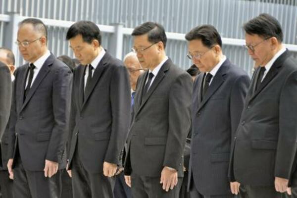 香港政府庁舎の広場で黙とうする李家超行政長官(中央)ら=29日(共同)