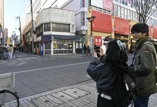 田村さん(右)のアドバイスを受けながら写真を撮る増渕さん