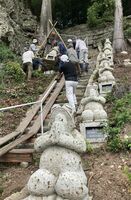 地元住民の手作業で参道に新たに設置されたカエルの石像「よみがえる」