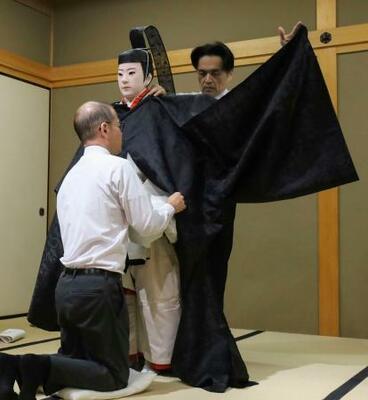 　人形に「衣紋」の技術で装束を着付ける宮内庁京都事務所の職員＝１０月、京都市上京区