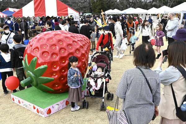 イチゴのオブジェの前で写真を撮る来場者ら