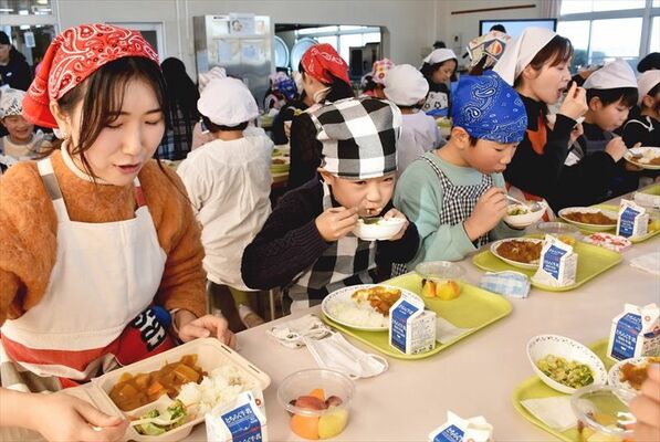 学生（左）と「想い出給食」を味わう子どもたち