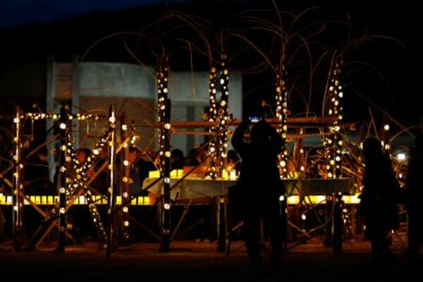 　宮城県石巻市の震災遺構・大川小でともされた竹あかり＝１１日午後６時７分