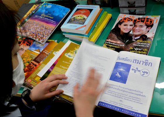 外部から差し入れられたタイ語の雑誌を確認する国際対策室の職員。外国語の書籍はすべてチェックされる=2015年2月27日午後