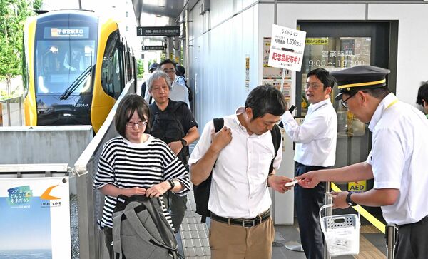 記念品を受け取るＬＲＴの利用者＝９日午後、宇都宮市宮みらい