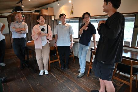 　商店街で開かれるイベントの運営を支えるボランティアのスタッフと談笑する田村寛さん（右から２人目）＝２０２５年７月、新潟市