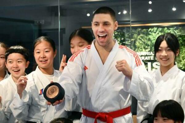 　返還された銅メダルを手に、笑顔で写真に納まるスタニスラフ・ホルナさん＝５日、東京都港区