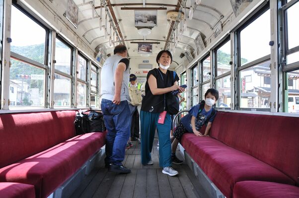 公開された路面電車の中を見学する観光客