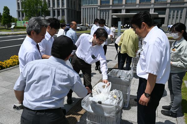 拾い集めたごみを分別する県職員＝17日午後、県庁昭和館前