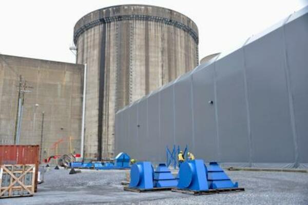 　スリーマイルアイランド原発２号機の原子炉建屋（中央奥）と建屋につながる廃炉作業用のハッチ＝４月、米ペンシルベニア州（共同）