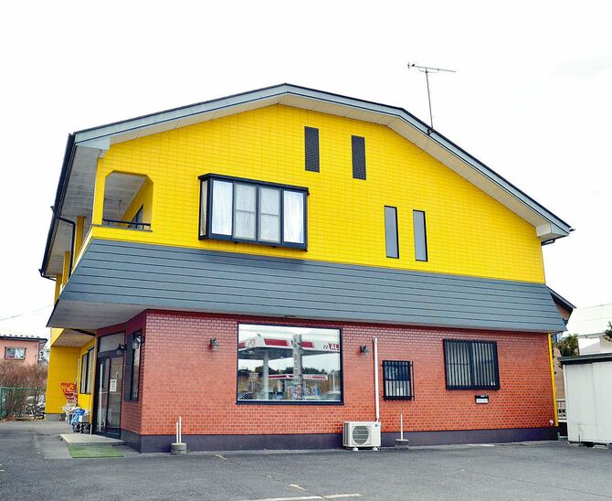 看板と黄色い建物が目印です