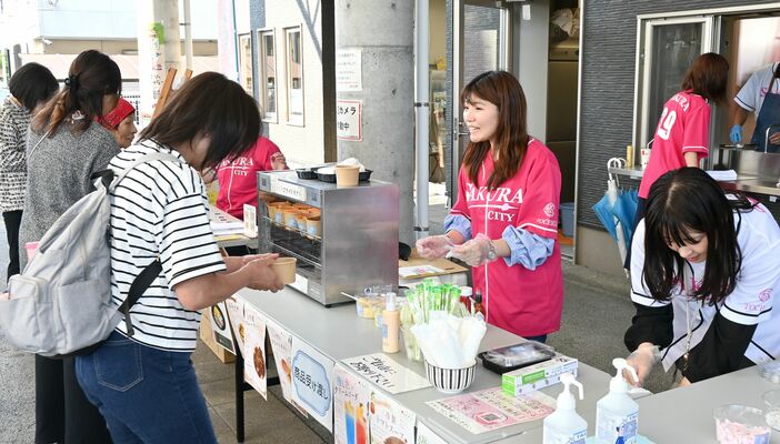 氏家駅前で行われたイベントで接客する斉藤さん(中央)=6月上旬、さくら市氏家