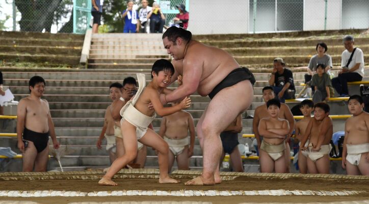 春日野部屋の力士の胸を借り、稽古に励む子どもたち＝県総合運動公園相撲場
