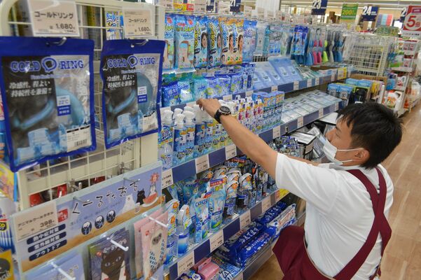 暑さ対策商品の棚を整える店員。猛暑日予報を前に陳列数を充実させた＝14日午後、栃木市薗部町