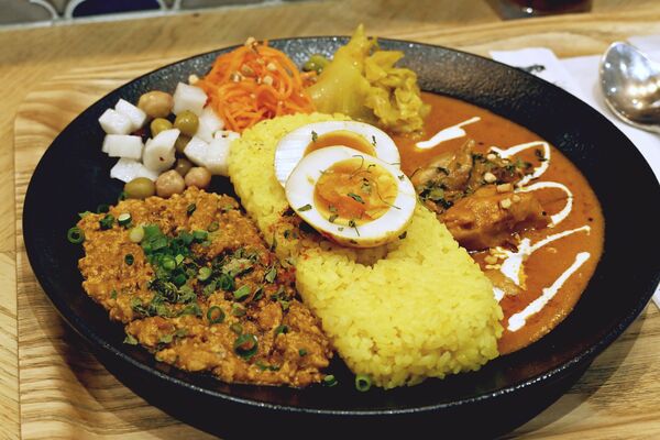 「スパイス煮卵」をトッピングした「合いがけカレー」
