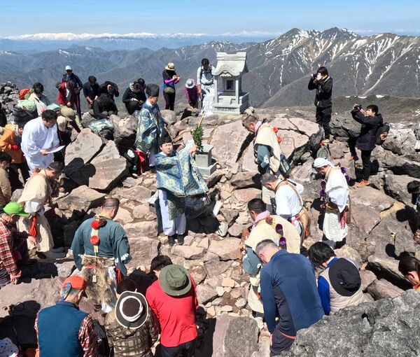 残雪の山並みを望む山頂で行われた開山祭の神事＝８日午前10時５分、那須町湯本