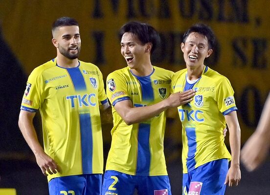 今季初の逆転勝利を飾り、栃木ＳＣのＤＦ平松（中央）がＦＷ大島（右）らと喜ぶ＝カンセキスタジアムとちぎ