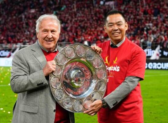 サッカーJ1で9季ぶりに優勝し、シャーレを手に写真に納まるジーコさんと鹿島の小泉文明社長(右)=6日、メルカリスタジアム