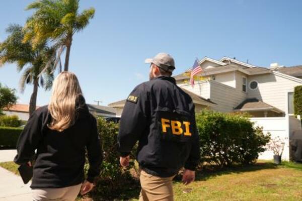 　容疑者の自宅近くで聞き込みに回るＦＢＩの捜査官＝２６日、カリフォルニア州トーランス（ＡＰ＝共同）