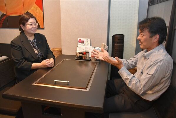 飲食店経営者とまちづくりについて意見交換する小沼市議（左）＝10月27日午後、足利市内
