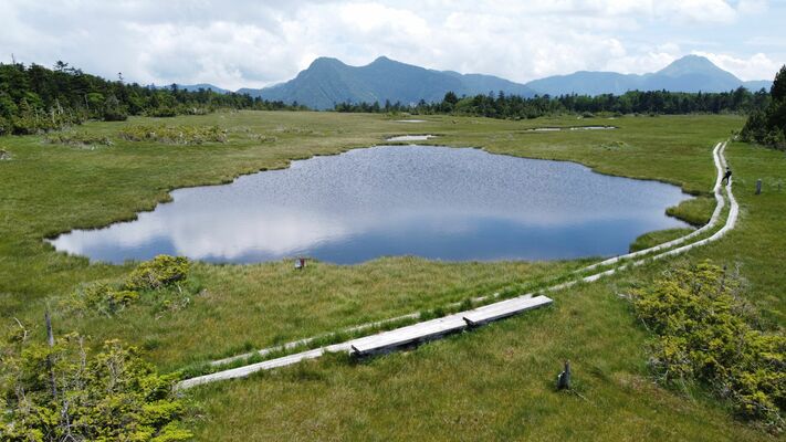 時折の晴れ間に青空と白い雲を映し出す鬼怒沼＝18日午後０時40分、日光市川俣、ドローンから