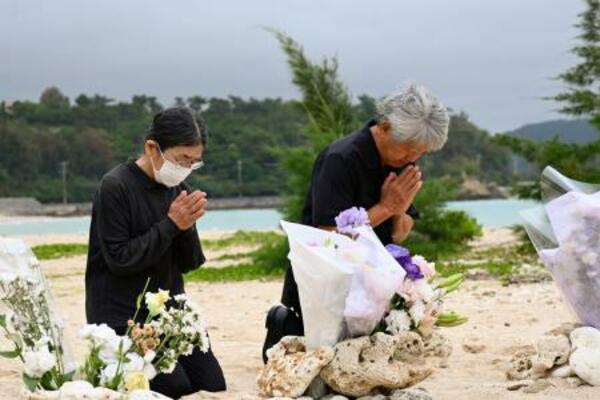 　転覆事故現場を臨む浜で手を合わせる「ヘリ基地反対協議会」の仲村善幸共同代表（右）ら＝３日午前、沖縄県名護市