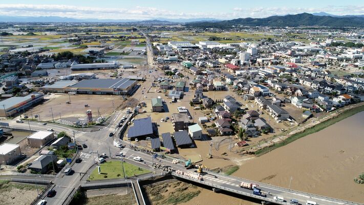 秋山川の堤防決壊（右下）で浸水した住宅街。河川の決壊や越水が各地で相次ぎ、住宅被害は県内全域に及んだ＝２０１９年10月13日午後０時35分、佐野市寺中町、小型無人機から