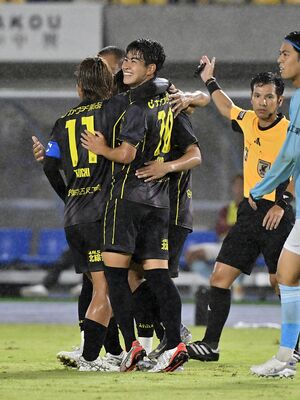 前半23分、３点目のシュートを決めた栃木ＳＣのＦＷ五十嵐（手前右）が仲間と笑顔で抱き合う＝カンセキスタジアムとちぎ、広瀬華撮影