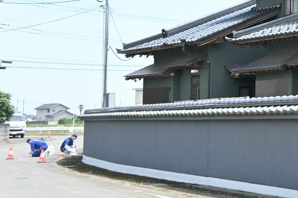 事件が発生した民家周辺で鑑識作業を行う県警捜査員＝14日午後０時45分、上三川町上神主