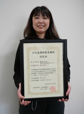 認定看護師教育機関としての認定証を手にする小西教授＝３月下旬、壬生町北小林