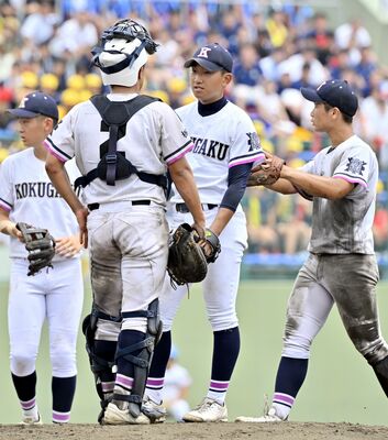 ５回、２死一、二塁のピンチで国学栃木の先発・鶴見（中央）のもとに内野陣が集まる＝エイジェック