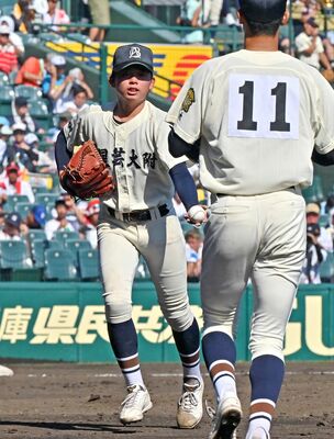 ５回、文星付の渋谷（左）が堀江にマウンドを託す＝甲子園球場