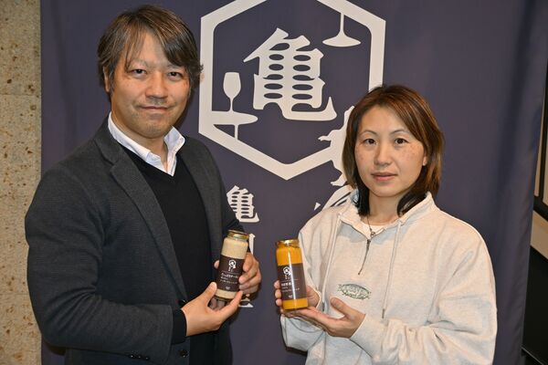 オリジナルドレッシングを手にする亀田社長（左）と粕谷さん＝宇都宮市川田町