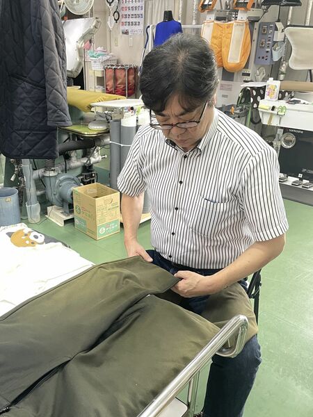 服の状態を確認する福冨さん