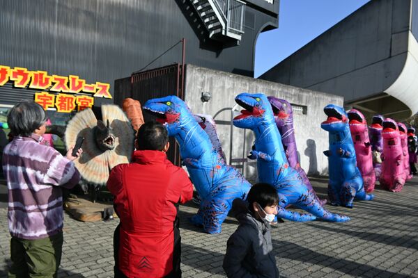 会場入りする恐竜姿の参加者たち