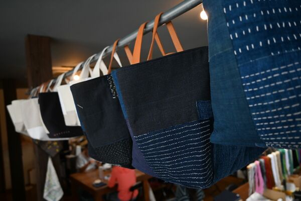 事業所には刺し子を施す利用者とそれらを縫製して製品化するスタッフが一緒に作業している