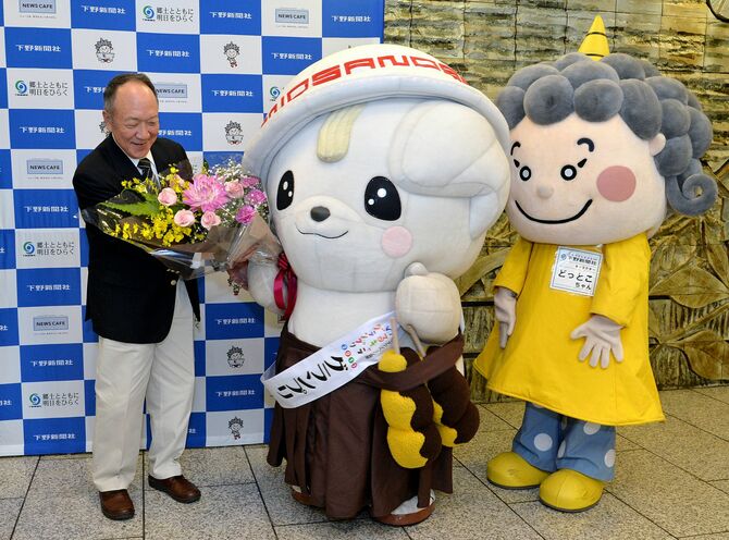 ゆるキャラグランプリで優勝した「さのまる」にお祝いの花束を贈る「どっとこちゃん」（2013年12月7日付）