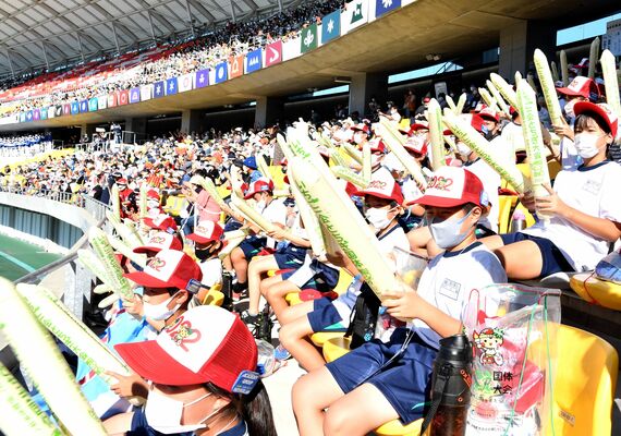 入場する選手団をスティックバルーンをたたいて応援する子どもたち＝１日午後２時25分、宇都宮市のカンセキスタジアムとちぎ
