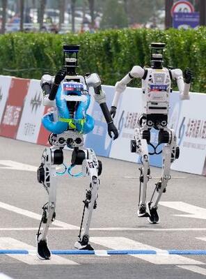 　ハーフマラソン大会で、次々とゴールする人型ロボット＝１９日、北京（共同）
