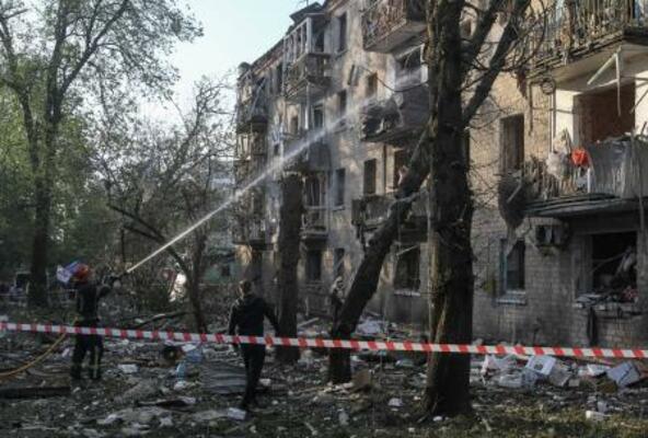 　ウクライナ・ドニプロで、ロシアのミサイル攻撃により損壊した建物付近で活動する消防士＝１８日（ロイター＝共同）