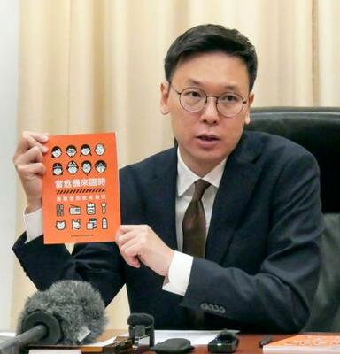 　ハンドブックを手に取材に応じる林飛帆氏＝１２日、台北市（共同）