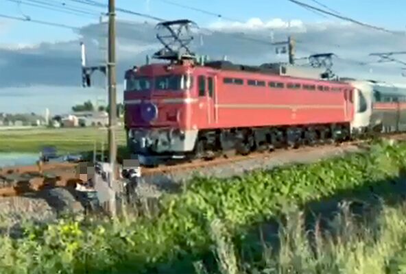 警笛を鳴らして通過するカシオペアと線路脇で撮影していたとみられる３人＝３日午後６時過ぎ、矢板市内（撮影者提供・画像は一部加工しています）
