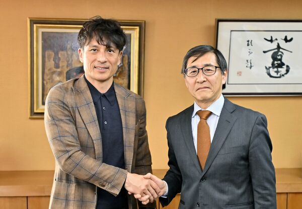若菜社長（右）と懇談し、握手する宮本会長＝21日午後、下野新聞社、杉浦崇仁撮影